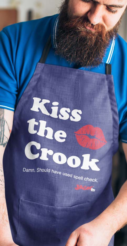 Photo of bearded man wearing a kiss the crook apron.